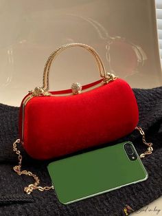 a red purse sitting on top of a table next to a green cell phone case