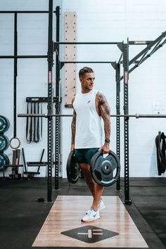 a man holding a weight plate in a gym