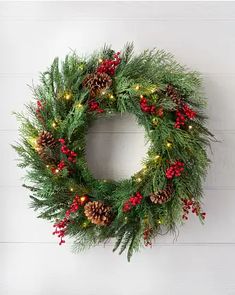 a christmas wreath hanging on the wall with lights and evergreens around it, which reads 34 in clear led wreath