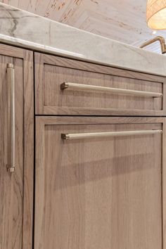 a kitchen with wooden cabinets and white marble counter tops on top of each cabinet door