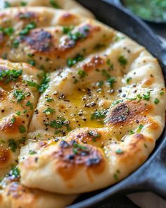 a close up of a pizza in a pan with cheese and chives on it