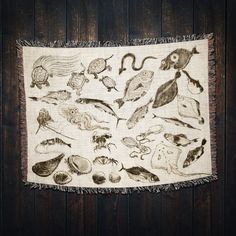 a table cloth with an image of various sea animals on it, hanging from a wooden wall