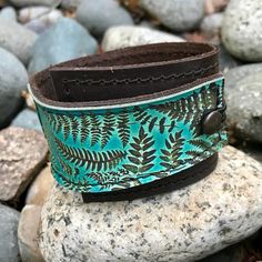 "This item is authentically handmade of genuine leather, the front has a photo digital image printed directly onto leather, produced in my studio. I've made this wrapping cuff out of soft leather, choose a black or brown base. Machine stitched, it has an attached elastic that hooks over a button, so this cuff will adjust to fit most wrist sizes 5.75\" to 7\" in circumference OR select a CUSTOM SIZE in the drop down menu. At the narrowest, the width of the cuff is 1.25\" and at the widest it's 2\ Handmade Green Leather Bracelet, Handmade Bohemian Leather Bracelet For Everyday, Bohemian Handmade Leather Bracelet For Everyday Use, Bohemian Handmade Leather Bracelet, Leather Bracelet For Women, Bracelet Vintage, Leather Gifts, Leather Cuffs, Nature Jewelry