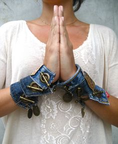 a woman in white shirt holding her hands together with two pairs of jeans on them