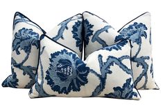 three blue and white pillows with flowers on them