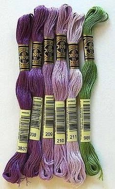 six skeins of purple and green yarn