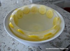 a white bowl filled with lemon slices on top of a counter