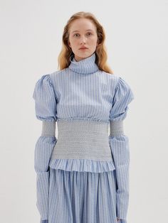 Editor's notesPuffed sleeves define our cotton-stretch victorian style top. Balance its proportions with flared jeans and sky-high wedges for a classic, chic look.- Victorian mood blouse- Combination color of sky blue stripe- High turtleneck with stitched edges- Long puff sleeves with smocked in the middle- Frilled hem - Button back closure- Smocked wide-waist band- Set up with smocked pants and skirt by EENKMeasurements(in.)- Size: XS, S, M- Shoulder: 15in / 15.51in / 15.98in- Chest: 35.63 Fitted Smocked Top For Daywear In Fall, Fitted Smocked Top For Fall Daywear, Fitted Smocked Cotton Top With Gathered Sleeves, Fitted Cotton Smocked Top With Gathered Sleeves, Light Blue Fitted Smocked Top For Spring, Fitted Light Blue Smocked Top For Spring, Spring Fitted Smocked Top With Blouson Sleeves, Chic Fitted Smocked Top For Work, Elegant Fitted Smocked Top With Elastic Sleeves