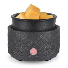 a black container with cheese cubes in it and a red light at the top