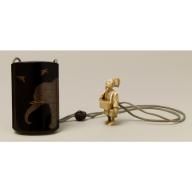 a gold figurine is next to a black canister with a white background