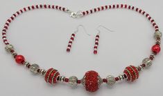 The 19 inch necklace is made with red sparkly round beads, red seed beads, round silver spacer beads and clear seed beads.  Necklace has a sterling silver lobster clasp and jump ring for closure.  Matching earrings are made with the red and clear seed beads.  Earrings have a sterling silver earring wire and hang a total of 1 1/2 inches in length. Red Beaded Sterling Silver Necklaces, Red Beaded Sterling Silver Necklace, Red Jewelry With Faceted Beads, Red Beaded Necklaces With Silver Beads As Gift, Red Beaded Sterling Silver Jewelry, Red Round Jewelry With Silver Beads, Red Round Silver Beaded Jewelry, Red Jewelry With Silver Beads, Red Sterling Silver Beaded Necklace