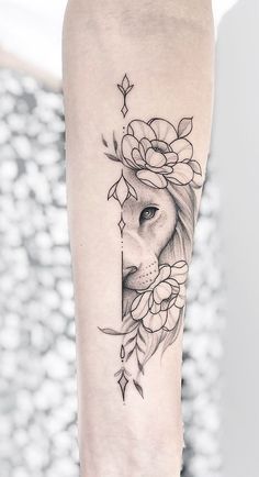 a woman's arm with a lion and flowers tattoo on the left inner forearm