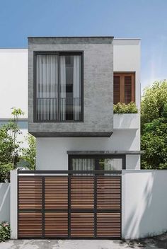 a modern house with wooden garage doors and two story windows on the side of it