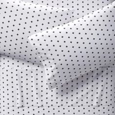 a white bed with blue stars on the sheets and pillow cases in front of it