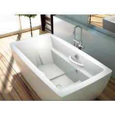 a white bath tub sitting on top of a wooden floor