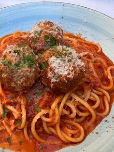 two meatballs and spaghetti on a plate