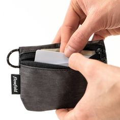 a person opening up a small wallet with a credit card in the other side pocket