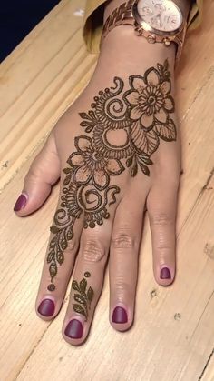 a woman's hand with henna tattoos on it