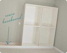 an empty room with white bookcases and green writing on the wall above it