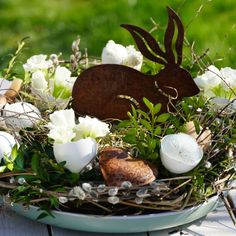 a basket filled with white flowers and an animal figurine sitting on top of it