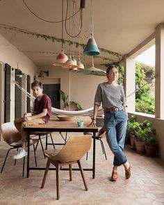 two people sitting at a table with hammocks hanging from the ceiling