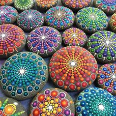 many colorful rocks are arranged together on the ground and painted with different colors, shapes and sizes