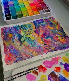 an artist's palette and watercolors on a table