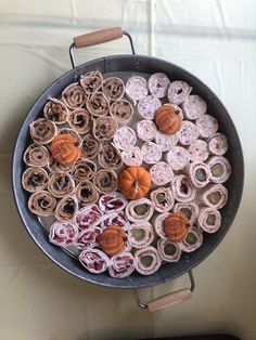 a pan filled with lots of different types of doughnuts on top of a table