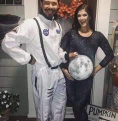 a man and woman dressed up as astronauts posing for a photo in front of a door