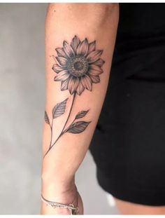 a woman's arm with a sunflower tattoo on it