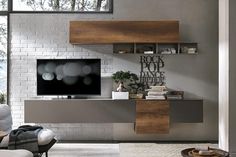 a living room filled with furniture and a flat screen tv on top of a wooden shelf