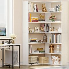 a white book shelf filled with books next to a desk and computer monitor on top of a hard wood floor