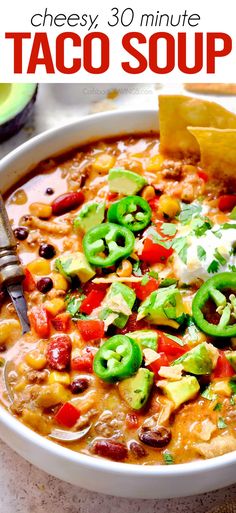 a white bowl filled with taco soup and tortilla chips on the side