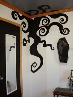 a black and white wall with an artistic tree on it's side next to a mirror