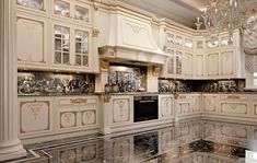 an elegant kitchen with marble floors and white cabinets, chandelier above the stove