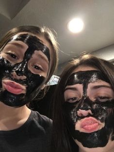 two girls with black facial masks on their faces