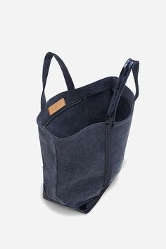 a denim tote bag with zippers on the inside