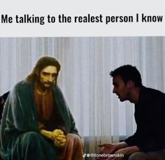 a man sitting on top of a couch next to a painting of jesus