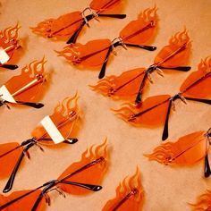 many orange pieces of paper with black handles and forks on them are arranged in the shape of arrows