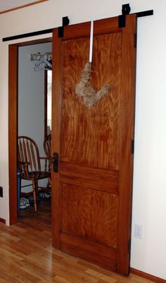 an open wooden door with rope hanging from it's sides in a living room