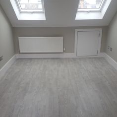 an empty room with two skylights in it