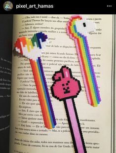 an open book with two pixel art - hams on top of each other and a rainbow stick in the middle