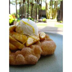 a waffle topped with ice cream and bananas on a blue plate in front of trees