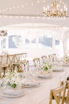 the tables are set up with white flowers and place settings for guests to sit at