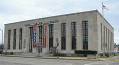 an old building with many windows and banners on the front, along with flags flying in the wind