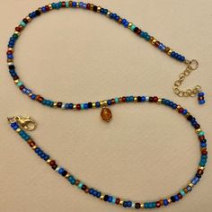 This 14K GF blue seed bead necklace ? Yes ! Your little extra "Je ne sais quoi " that makes all the difference ! You deserve to treat yourself !  Wear it as a solo or in a stacking style. * Materials:  14K GOLD FILLED high quality clasp and extension chain. Gold-filled is a thick layer of gold on metal, a higher-quality material than gold-plated. Pendant : Faceted glass bead diam 6mm. Best quality glass seed beads. * Size: The necklace is a choker that measures 39 cm + an extension chain of 3 cm Cheap Blue Beaded Necklaces With Colorful Beads, Boho Beads Necklace, Unique Blue Beaded Necklace, Adjustable Blue Beaded Necklace With Colorful Beads, Fall Seed Bead Necklace, Cute Blue Necklace With Colorful Beads, Playful Blue Adjustable Beaded Necklace, Blue And Red Beaded Necklace, Blue Seed Bead Necklace