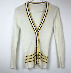 Vintage MCM Women’s Knit Cardigan Sweater; brand tag has been removed; Collegiate Preppy Style; Cream with Navy & Gold Stripes; Vintage Size 8. Condition is very nice preowned; appears to have manufacturer’s flaw in knit near left cuff; please note in photos; this garment is a neat style and was originally owned by seller’s grandmother; selling only because daughter has outgrown it; Appears to run small compared to current sizes, so please compare your measurements with the measurements in p Retro Fitted Sweater For Work, Retro White Knit Cardigan, White Fitted Retro Cardigan, White Knit Retro Cardigan, Vintage White V-neck Outerwear, White Preppy Cardigan For Fall, Preppy White Cardigan For Fall, Vintage Spring Cardigan For Workwear, Retro Long Sleeve Cardigan For Work