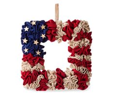 the letter decorated with red, white and blue ruffles is hanging on a clothes line