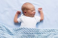 a baby laying on top of a blue blanket