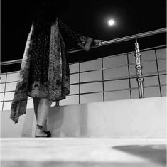 black and white photograph of woman walking up stairs at night